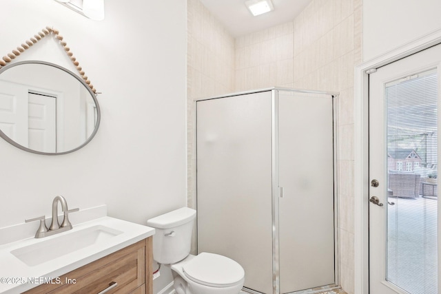 full bathroom with a stall shower, toilet, and vanity