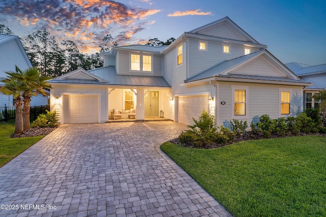290 Marquesa Cir, Saint Johns, FL 32259 - view of front of house featuring covered porch, metal roof, a front yard, decorative driveway, and an attached garage