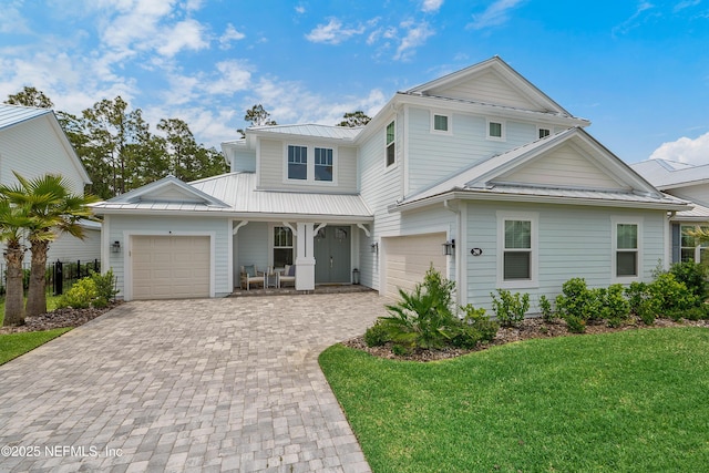 290 Marquesa Cir, Saint Johns, FL 32259 - view of front of home with a porch, metal roof, a front yard, a garage, and decorative driveway