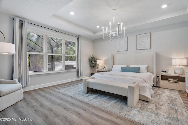 290 Marquesa Cir, Saint Johns, FL 32259 - bedroom with wood finished floors, baseboards, an inviting chandelier, a tray ceiling, and recessed lighting