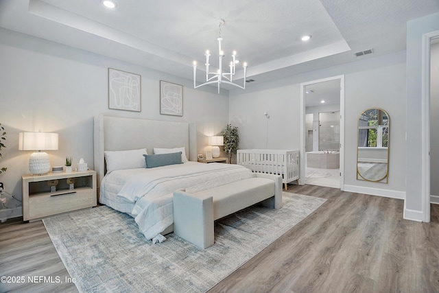 290 Marquesa Cir, Saint Johns, FL 32259 - bedroom with visible vents, wood finished floors, a raised ceiling, a notable chandelier, and recessed lighting
