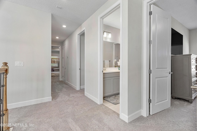 290 Marquesa Cir, Saint Johns, FL 32259 - hall with a sink, baseboards, a textured ceiling, and light colored carpet
