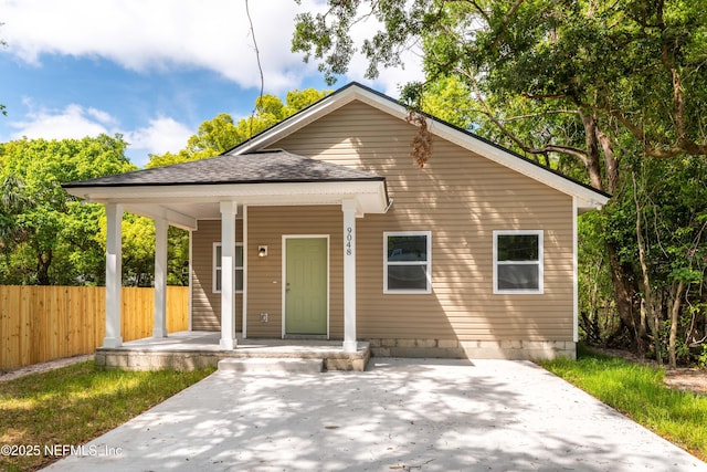 bungalow featuring fence, a porch, and a shingled roof