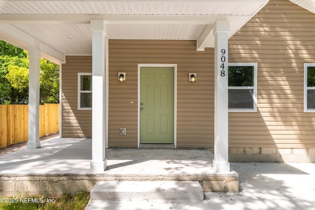 property entrance featuring fence and a porch