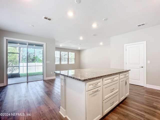kitchen with a center island, visible vents, and wood finished floors
