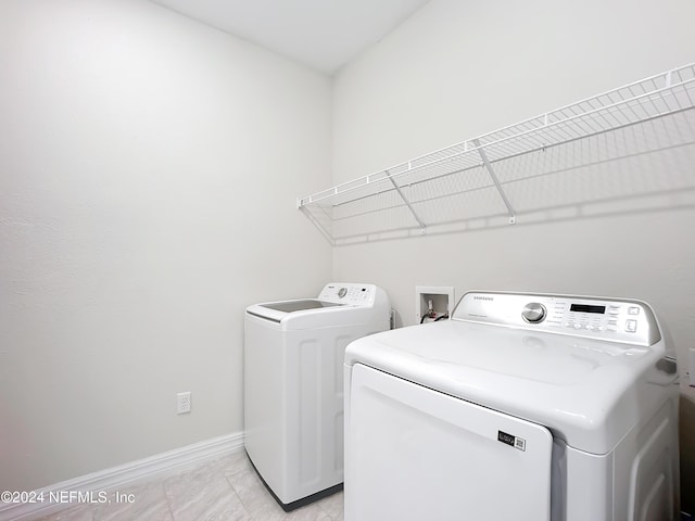 laundry room featuring washing machine and clothes dryer, laundry area, and baseboards