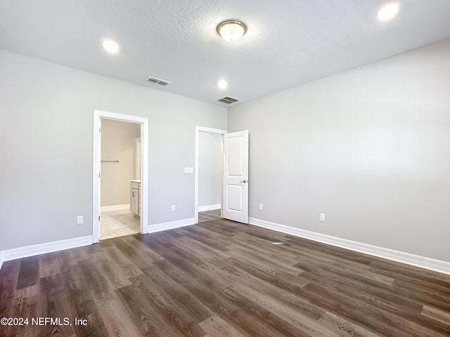 unfurnished bedroom featuring visible vents, wood finished floors, and baseboards