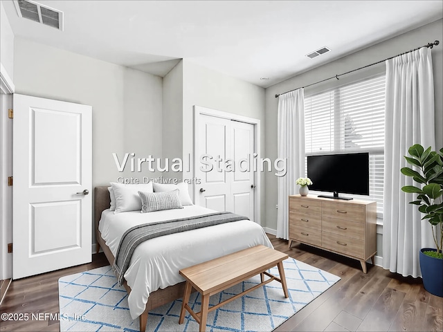 bedroom featuring visible vents, dark wood-style flooring, and a closet
