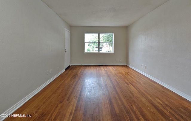 unfurnished room with wood finished floors and baseboards