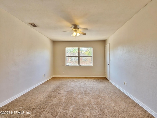 empty room featuring baseboards, visible vents, a ceiling fan, and carpet floors