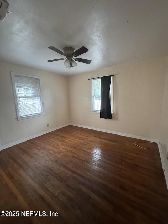 empty room with a ceiling fan, wood finished floors, and baseboards