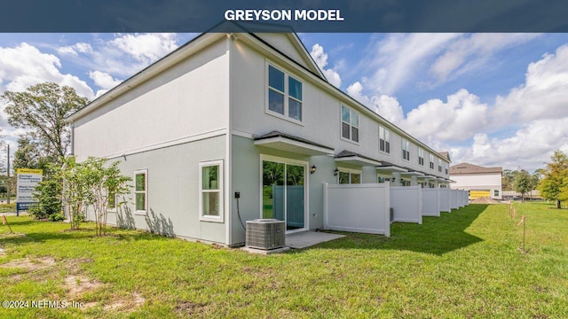 rear view of house with fence, cooling unit, a yard, and stucco siding