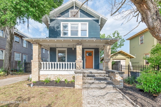 craftsman-style home featuring a porch and fence