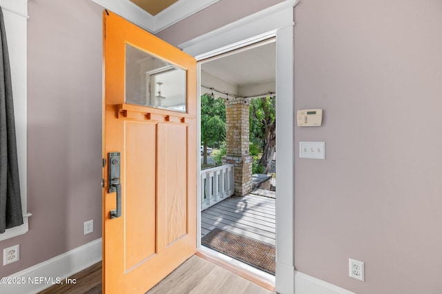 doorway with baseboards and wood finished floors