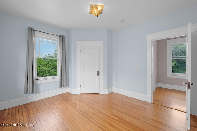 spare room with light wood-type flooring and baseboards