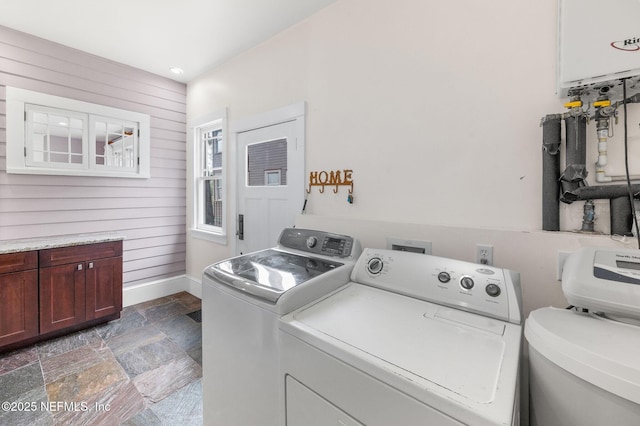 washroom featuring washer and dryer, wooden walls, stone tile floors, recessed lighting, and baseboards