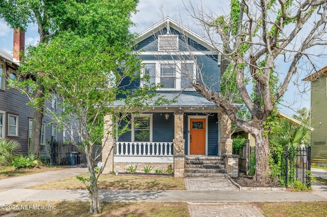 craftsman inspired home featuring central air condition unit, fence, and covered porch