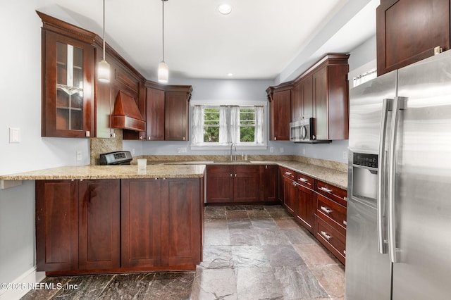 kitchen with pendant lighting, appliances with stainless steel finishes, light stone countertops, a sink, and a peninsula