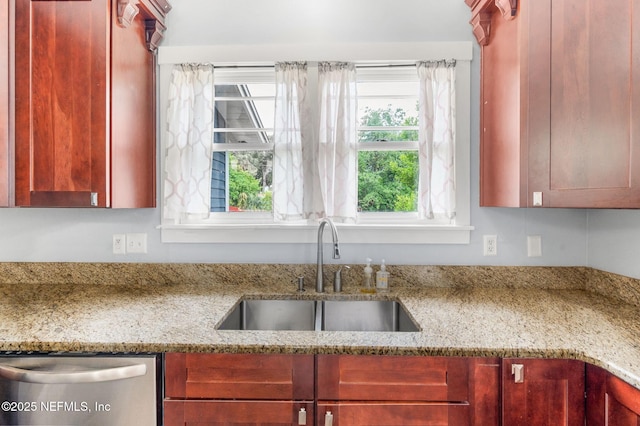 kitchen featuring stainless steel dishwasher, dark brown cabinets, light stone counters, and a sink