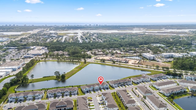 aerial view of property and surrounding area featuring a large body of water and nearby urban area