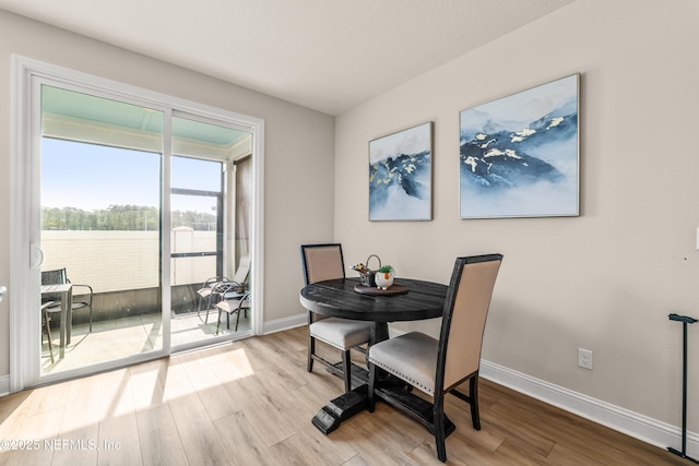 dining space with wood finished floors and baseboards