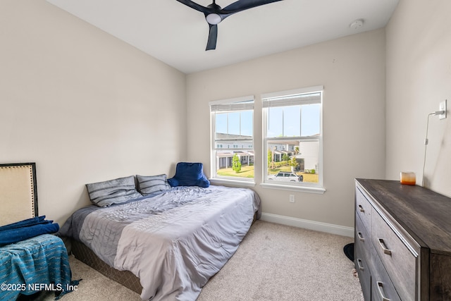 bedroom featuring light carpet, baseboards, and ceiling fan