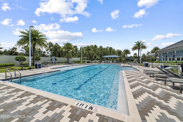 community pool featuring fence and a patio