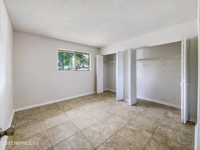 3801 Crown Point Rd Unit 1311, Jacksonville, FL 32257 - unfurnished bedroom featuring tile patterned flooring, a textured ceiling, and multiple closets