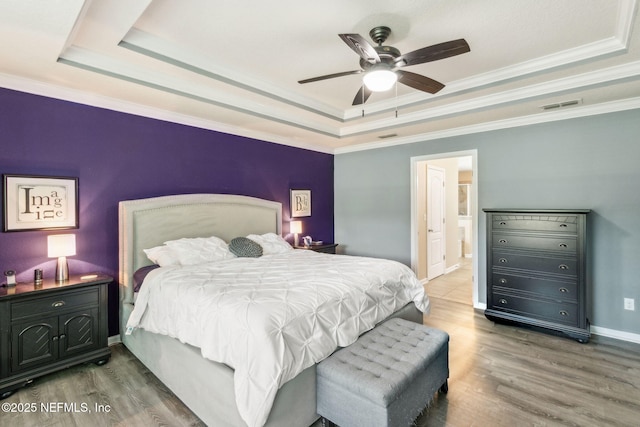 417 Palazzo Cir, Saint Augustine, FL 32092 - bedroom with a tray ceiling, wood finished floors, ensuite bath, ceiling fan, and crown molding