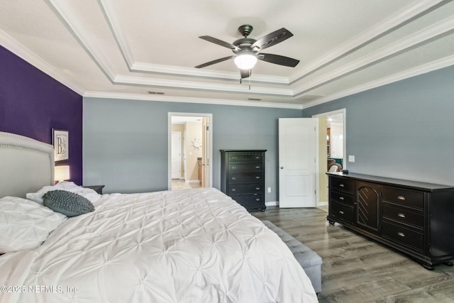 417 Palazzo Cir, Saint Augustine, FL 32092 - bedroom featuring a tray ceiling, wood finished floors, crown molding, ceiling fan, and ensuite bath