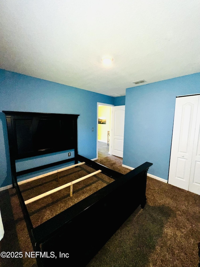 bedroom featuring visible vents, a closet, baseboards, and carpet floors