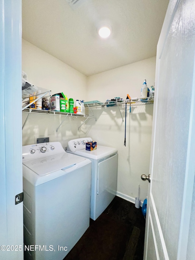 clothes washing area featuring baseboards, laundry area, and washing machine and dryer