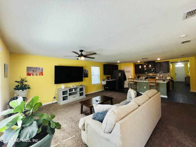 living room with baseboards, visible vents, dark colored carpet, and ceiling fan