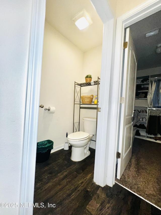 bathroom featuring toilet, wood finished floors, and baseboards