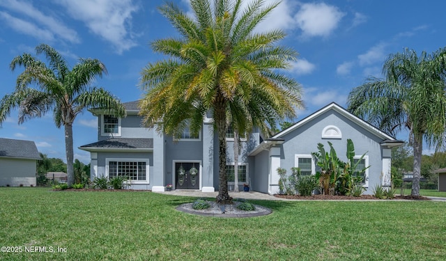 greek revival inspired property with stucco siding and a front yard