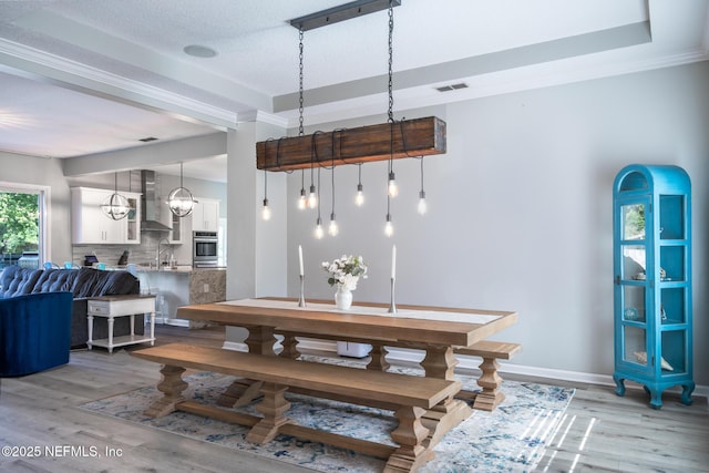 dining room with visible vents, light wood-style flooring, and baseboards