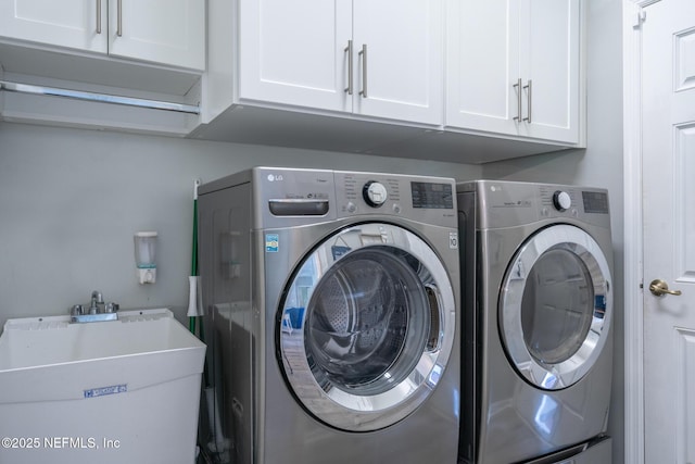 clothes washing area with washer and dryer, cabinet space, and a sink