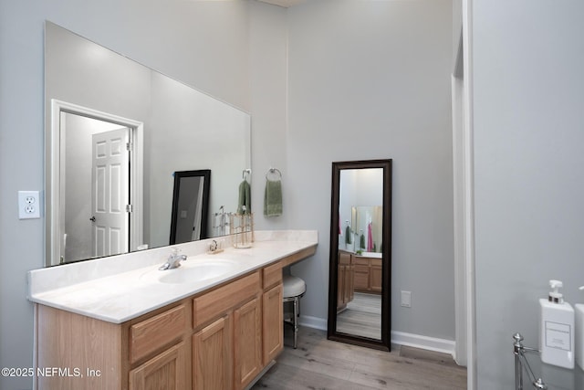 bathroom with baseboards, wood finished floors, and vanity