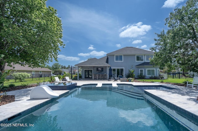 view of pool featuring a fenced in pool, a patio area, a water slide, fence, and french doors