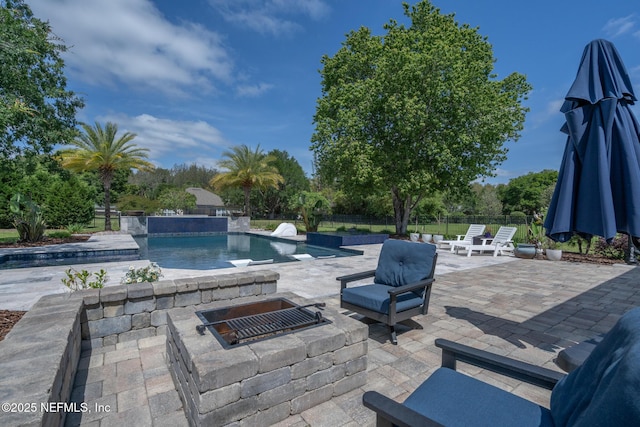 view of patio featuring a fire pit, fence, and a fenced in pool