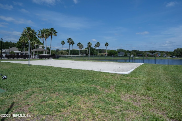 view of home's community with volleyball court, a lawn, and fence