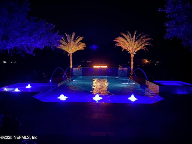 pool at twilight with an in ground hot tub