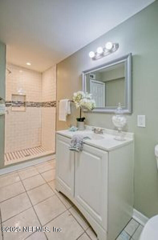 9717 Carbondale Dr W, Jacksonville, FL 32208 - full bath featuring tile patterned floors, vanity, toilet, and a stall shower