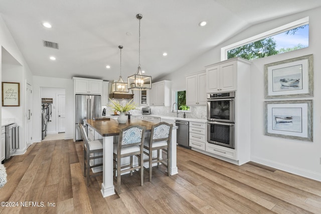 1246 Neck Rd, Ponte Vedra Beach, FL 32082 - kitchen featuring backsplash, appliances with stainless steel finishes, vaulted ceiling, a sink, and white cabinets