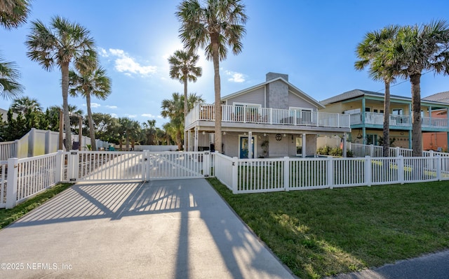 view of front of property featuring fence private yard, a gate, and a front lawn