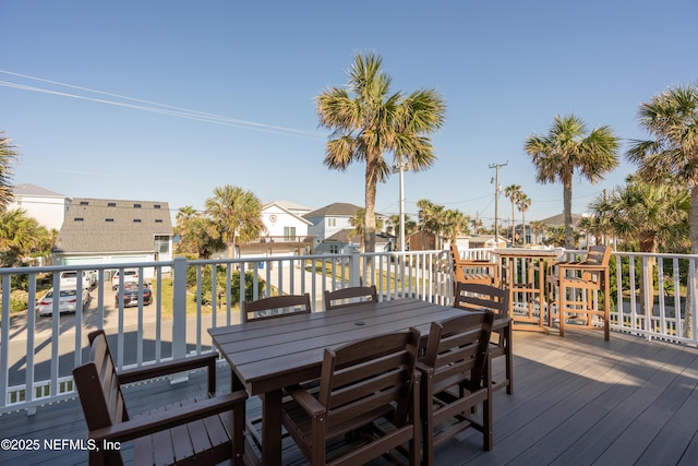 wooden terrace featuring a residential view and outdoor dining area