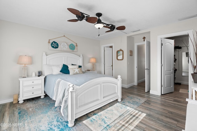 bedroom with wood finished floors, a ceiling fan, visible vents, and baseboards