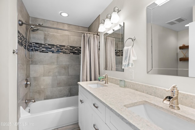 bathroom featuring visible vents, shower / bath combo with shower curtain, double vanity, and a sink