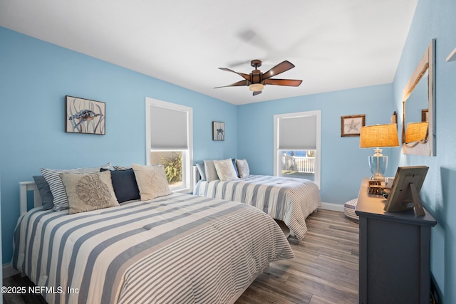 bedroom with ceiling fan, wood finished floors, and baseboards