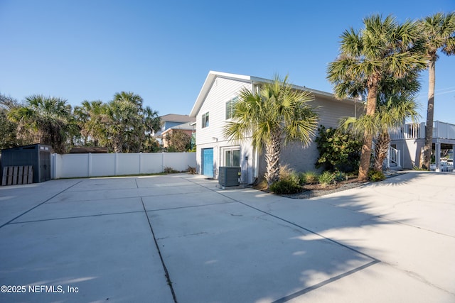 view of home's exterior featuring fence, driveway, and central air condition unit